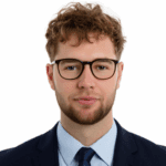 Porträt eines Livello-Teammitglieds mit Brille und lockigem Haar im dunklen Anzug